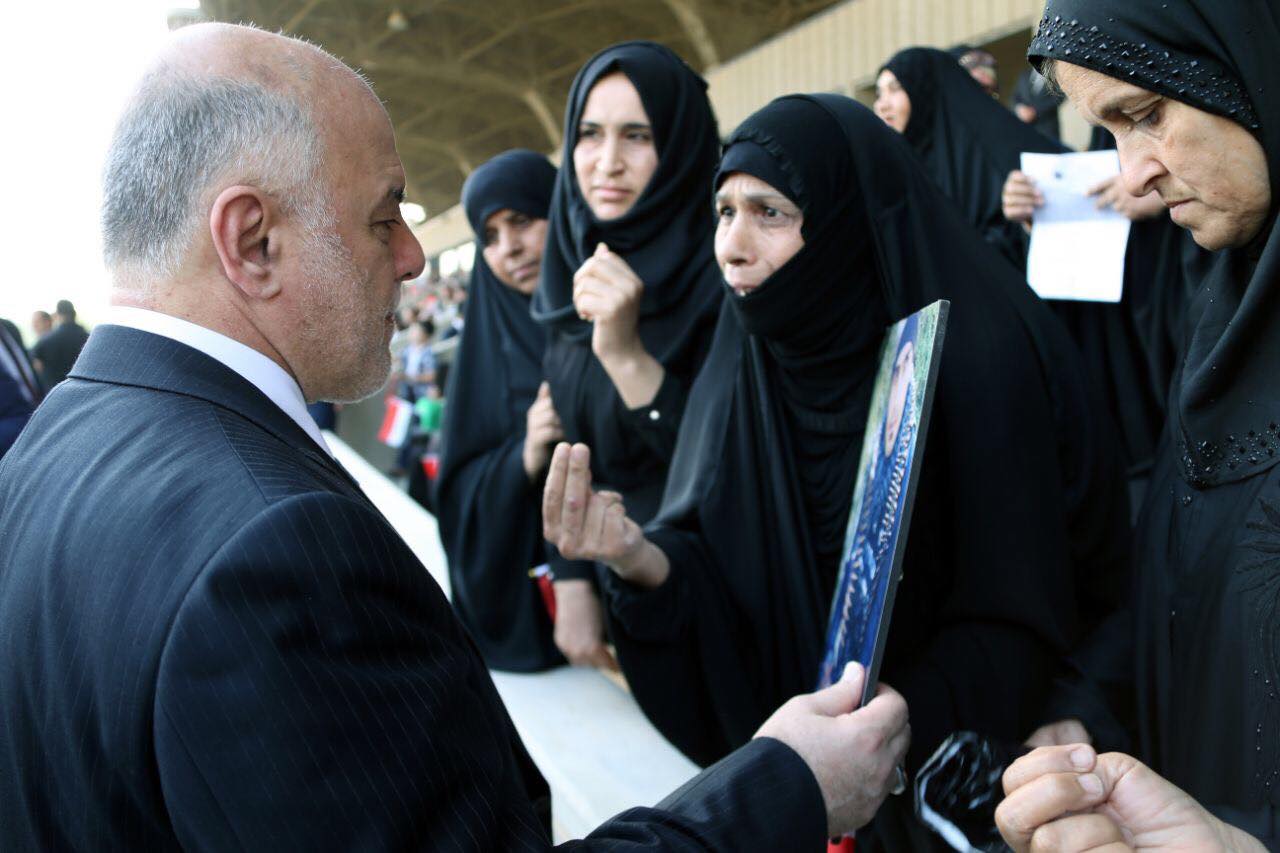 Iraqi Prime Minister Haider al-Abadi with the families of the fallen Iraqi soldiers during the military parade in Baghdad, July 15, 2017. (Photo: Iraqi Prime Minister’s Press Office)